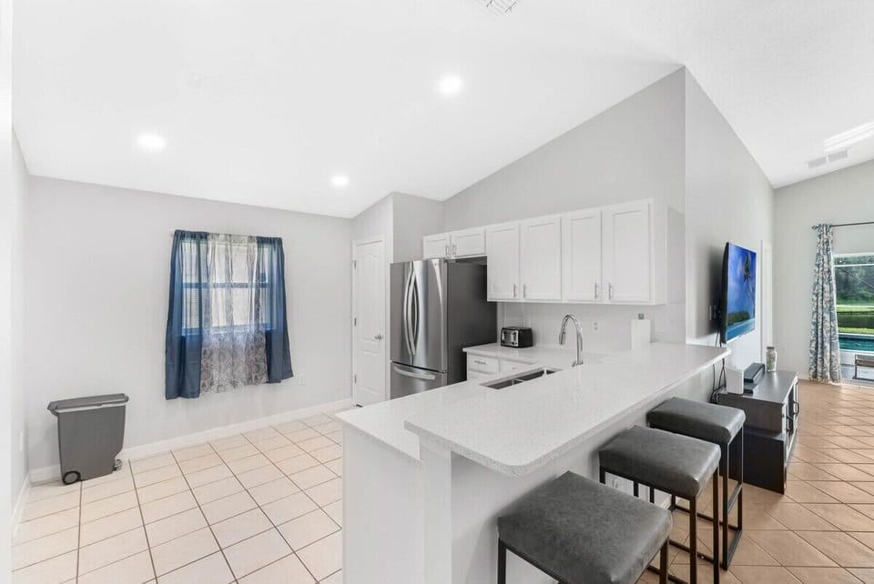 The perfect setup for social families! This spacious kitchen features plenty of counter space and high-top seating, making it easy to serve casual snacks or a full family feast.