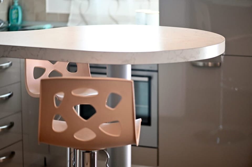 Cucina completa di accessori con penisola e sgabelli, angolo cottura a gas con 4 fuochi, lavastoviglie, forno, frigo, freezer