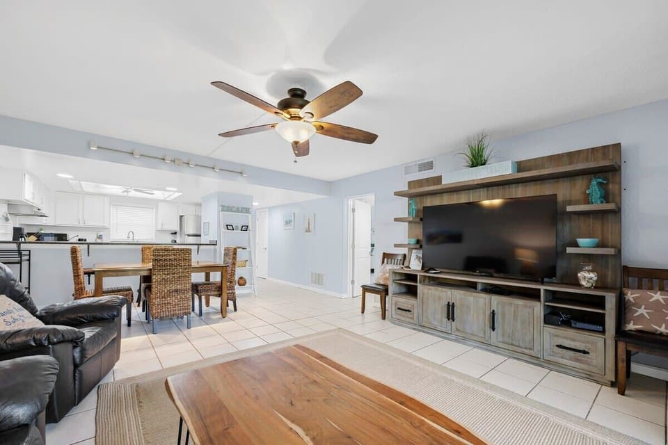 Open living area with a large flat-screen tv and dining space in a bright, casual setting.