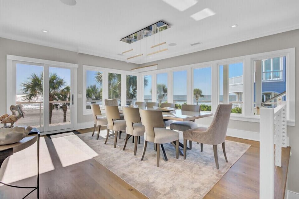 Gather the crew for unforgettable meals with a panoramic beachfront backdrop - Dine in style under a sleek chandelier surrounded by sunshine and swaying palms - Every seat offers a front row view of the waves just steps from your table