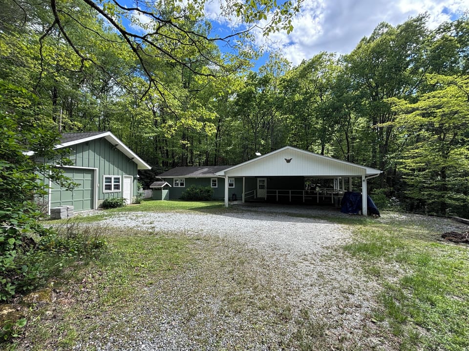 6.5 acres with a big flat useable area, carport, and garage. 