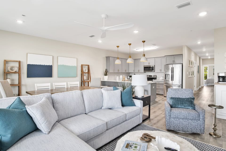 Live the dream in this airy haven where plush textures and cool hues blend with an open, inviting kitchen, perfect for social living.