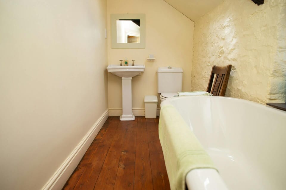 En-suite bath with WC, wash hand basin and wall mounted mirror