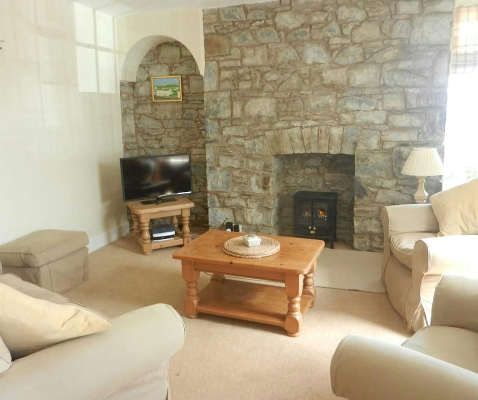 Living room with fireplace, tv, sofas and armchairs