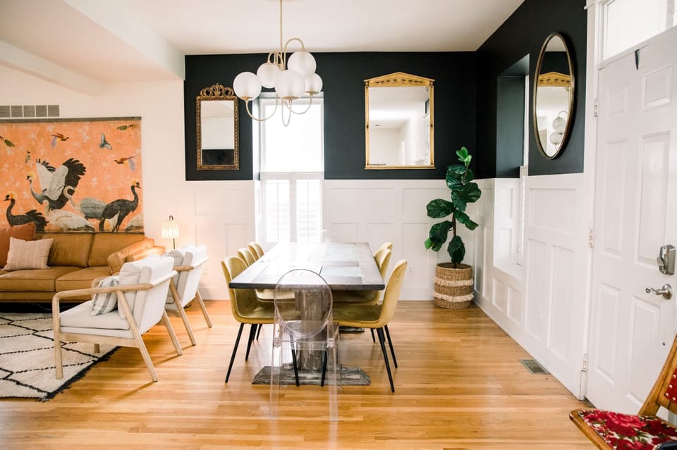 Inviting living room blends modern and eclectic decor—tan leather sofa, bold wall art, and plush chairs for group gatherings 🛌🎨
