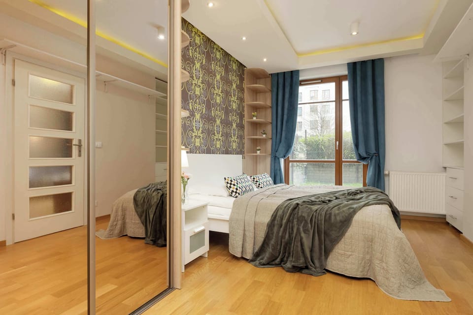 Comfortable bed, wood furniture, and large wardrobe.