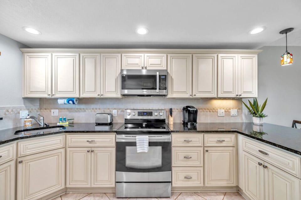 Clean, well-lit kitchen w/ classic cabinetry and everything needed for everyday cooking.