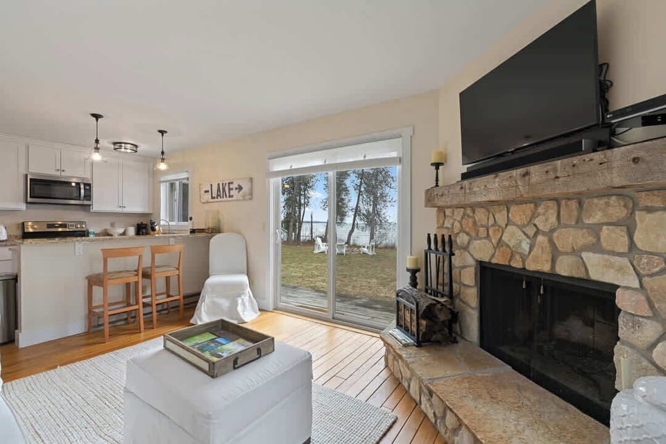 Updated and comfortable main living space offers a wood burning fireplace, SMART TV, and views of the private lakeshore