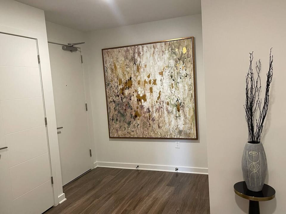 Entryway with the door to where the washer-dryer combo machine is located.