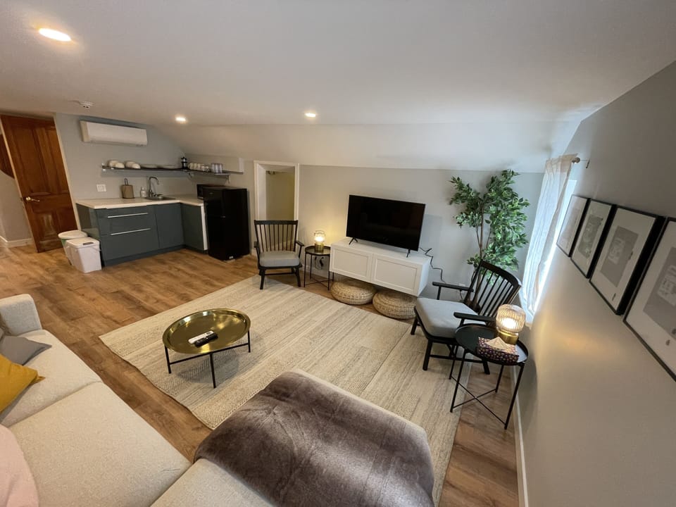 living room, kitchenette, and emergency exit hallway