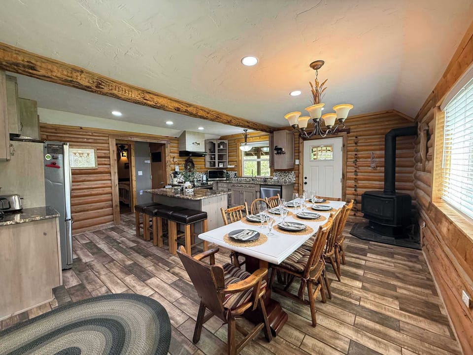 Gather everyone together at the grand dining table, beautifully lit by an elegant country chandelier and warmed by the cozy wood-burning stove nearby.