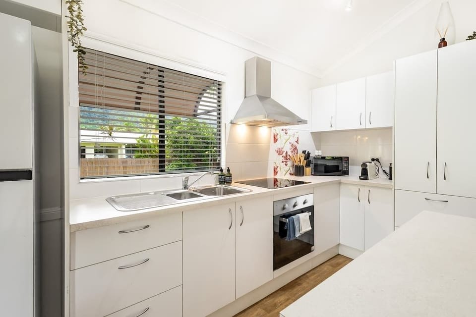 The fully equipped kitchen makes holiday dining simple, complete with modern appliances, generous bench space, and a Nespresso machine ready for slow mornings at home.
