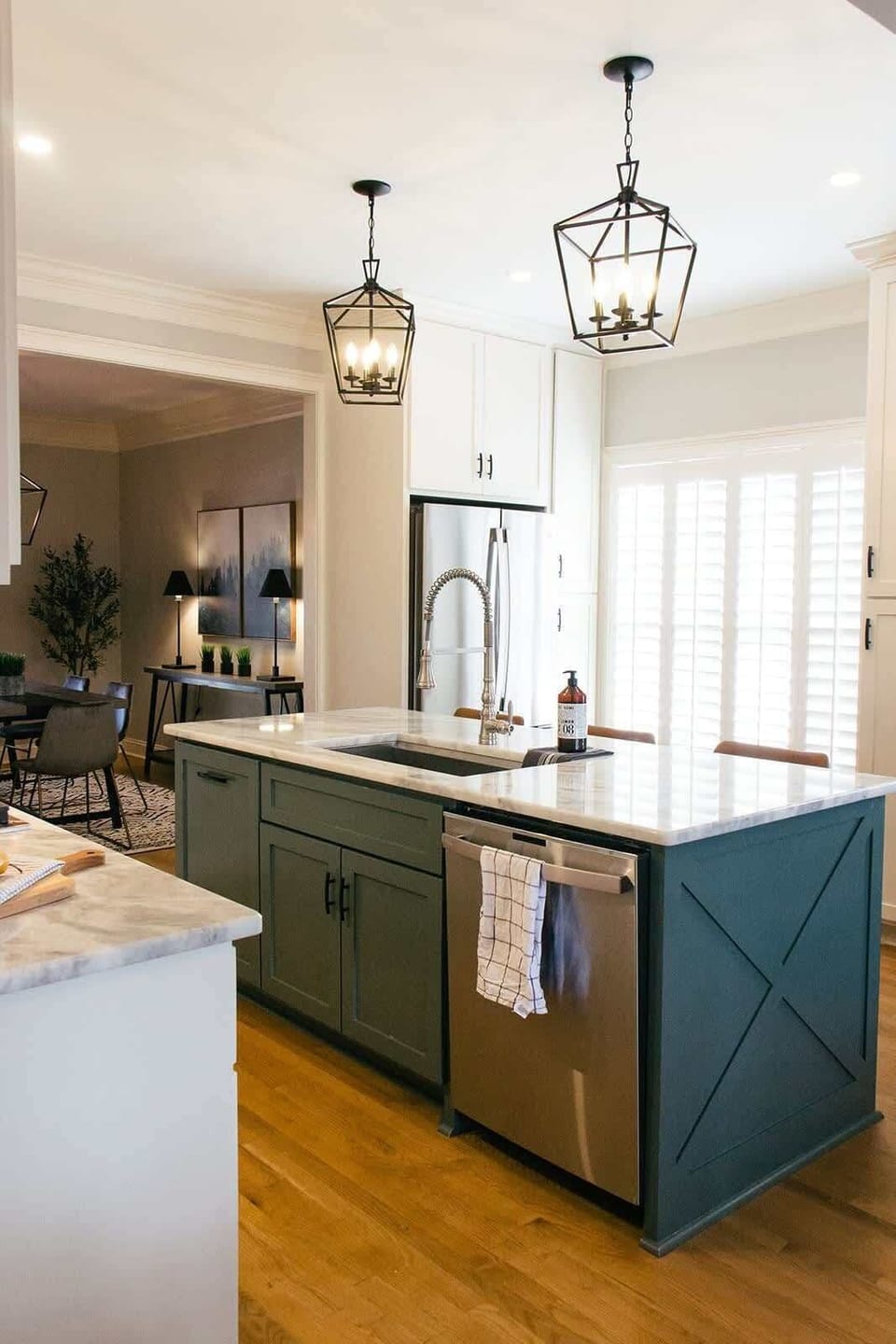 A striking green island with a sleek white marble top anchors the kitchen.