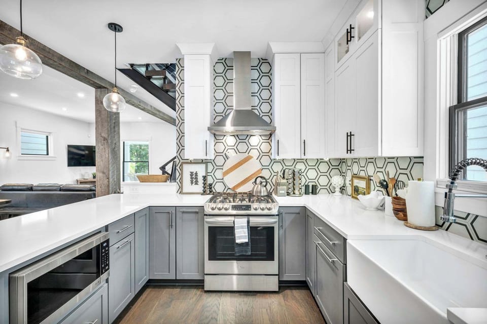 Experience the sleek design of our fully equipped kitchen, featuring stainless steel appliances, ample counter space, and a chic hexagonal tile backsplash. Perfect for preparing meals and making lasting memories.