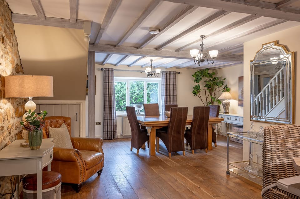 Dining area with wooden table and exposed beams at Sun Hill Cottage.