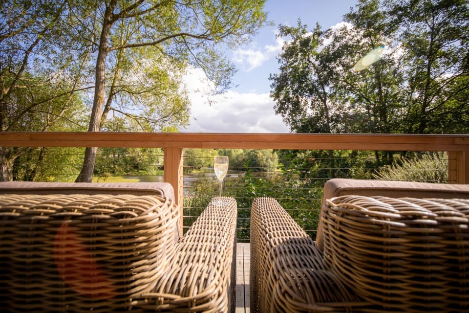 Decking of Imogen lodge at Brompton Lakes with outdoor seating and lakeside views.