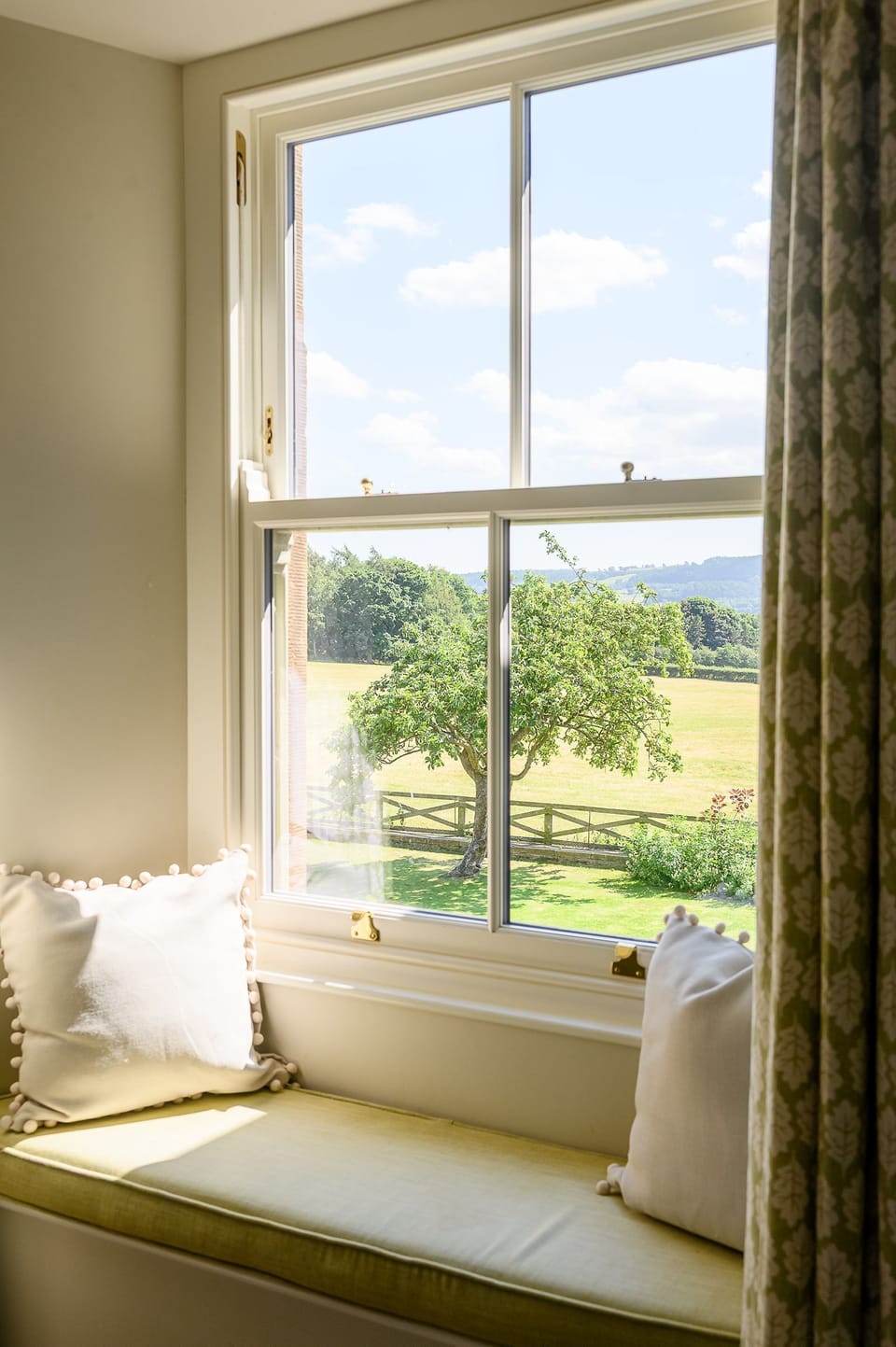 Cosy bedroom window seat at Hollins Farmhouse with views across the gardens and surrounding countryside.