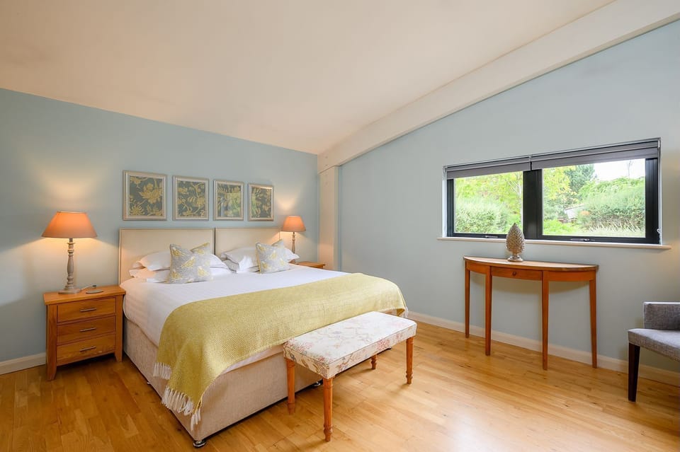 Jasper lodge stylish bedroom with large window views and soft blue decor.
