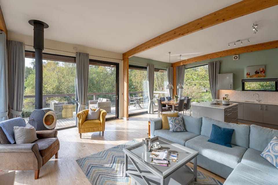 Open-plan lounge and kitchen with modern interiors and natural light in Jasper lodge at Brompton Lakes.