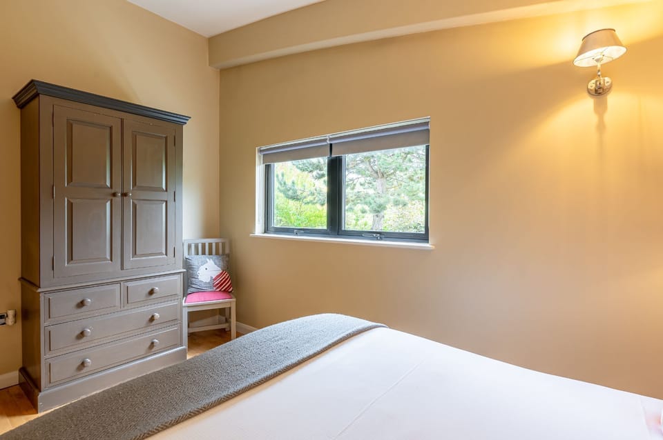 Double bedroom in William lodge at Brompton Lakes with neutral tones, wardrobe and countryside views.