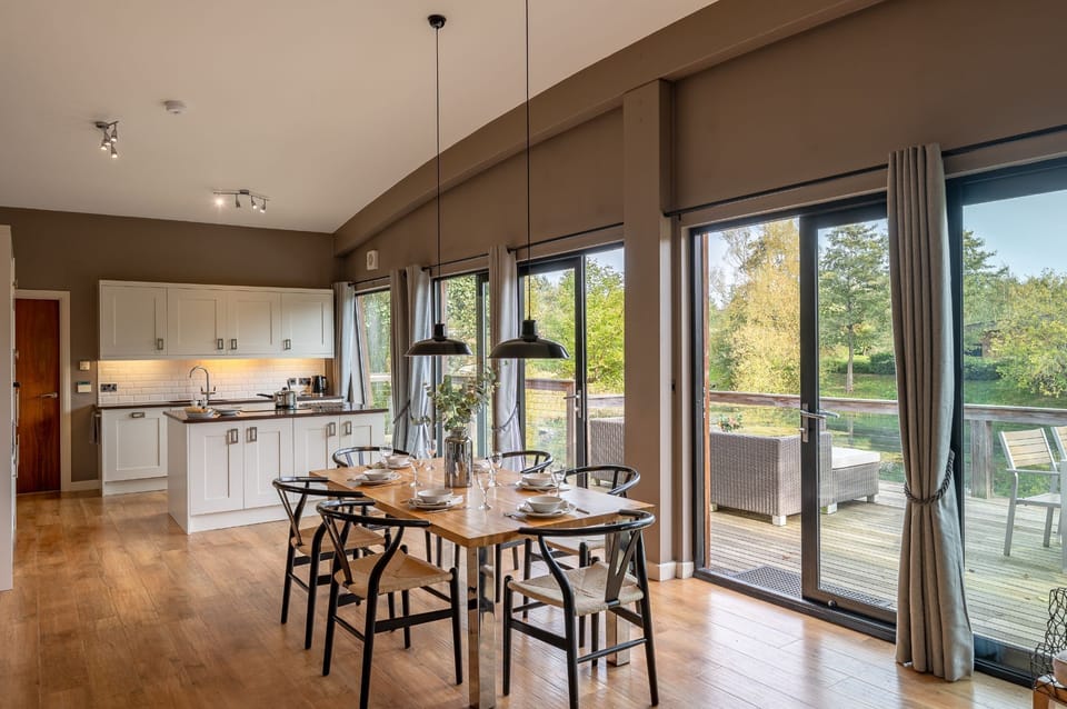 Bright open-plan kitchen and dining area at Willow, with large doors leading out to the private decking.
