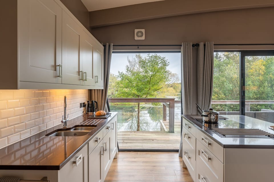 Kitchen at Willow, with a central island and large doors opening onto the private lakeside decking.
