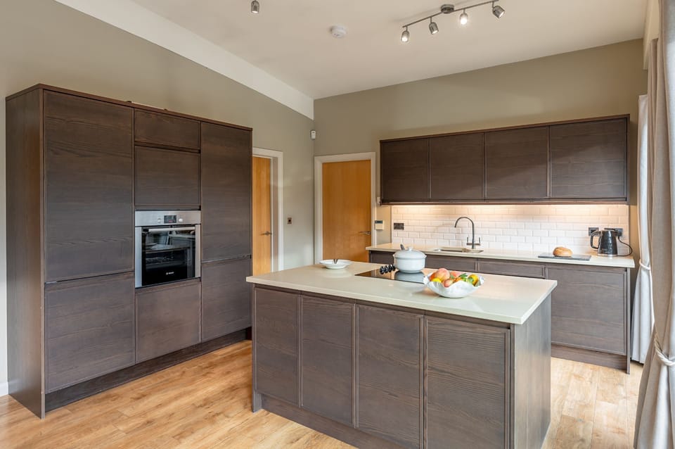 Fully equipped contemporary kitchen with island and high-end finishes in Juniper Lodge, Brompton Lakes.