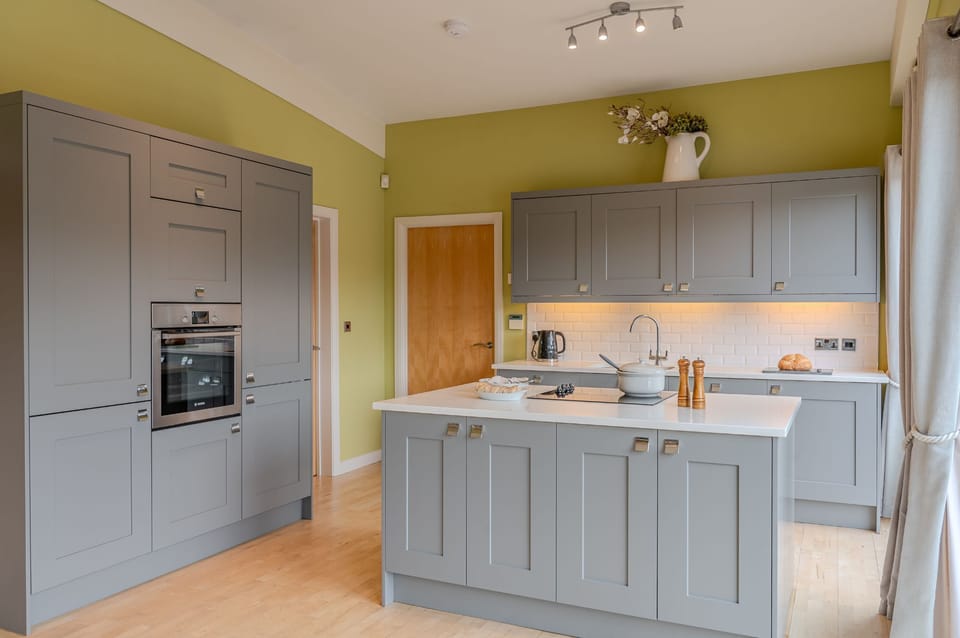 Modern, fully equipped kitchen at Louis lodge with island and grey cabinetry.