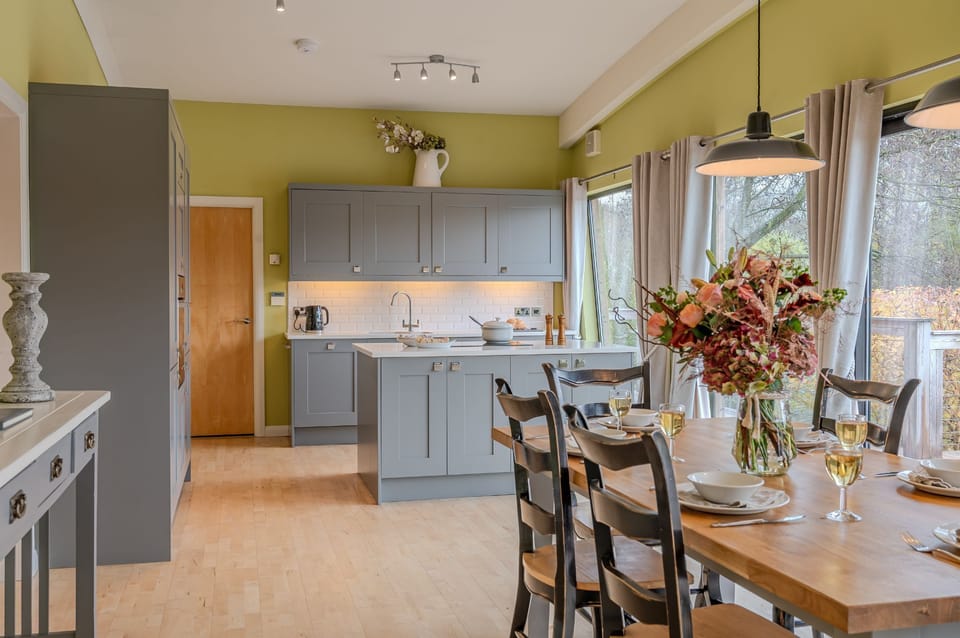 Modern, fully equipped kitchen at Louis lodge with island, grey cabinetry and dining area.