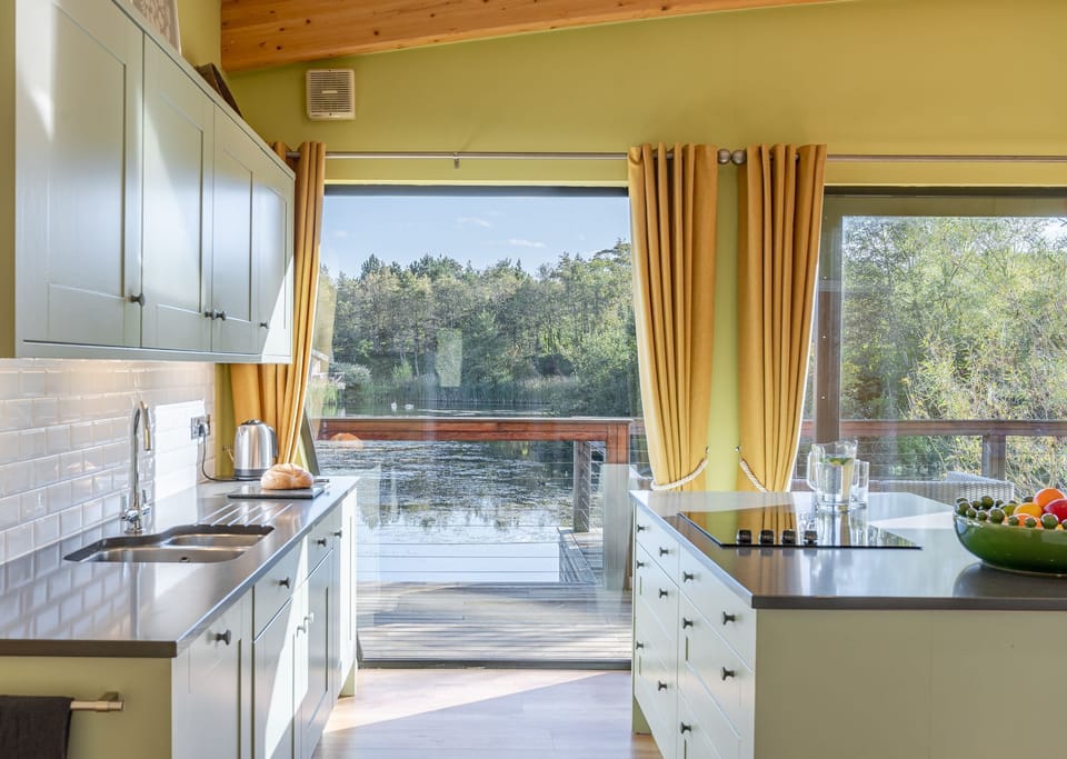 Modern kitchen interior with island in Florence lodge at Brompton Lakes with stylish furnishings and natural light.