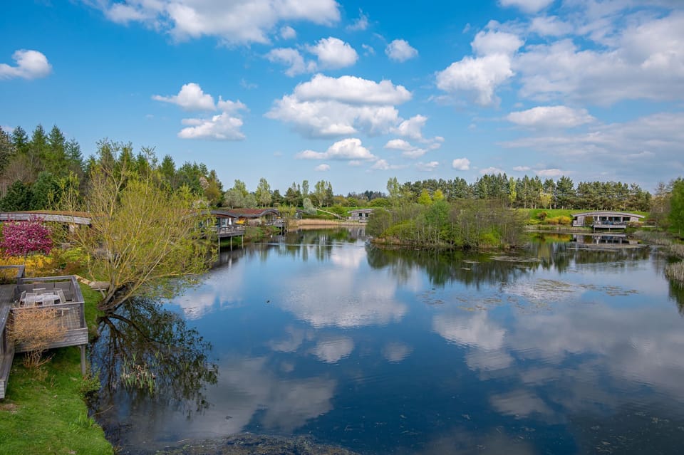 Exterior of Florence lodge at Brompton Lakes overlooking tranquil lake with luxury lodges in Yorkshire countryside.