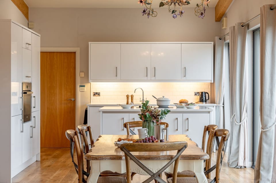 Open-plan kitchen and dining area in Charlie lodge at Brompton Lakes with large windows.