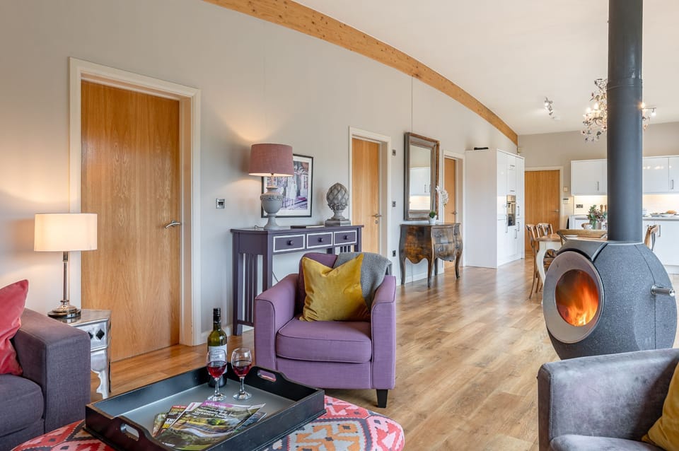 Contemporary interior in Charlie lodge at Brompton Lakes with stylish furnishings, relaxing seating area and log burner.