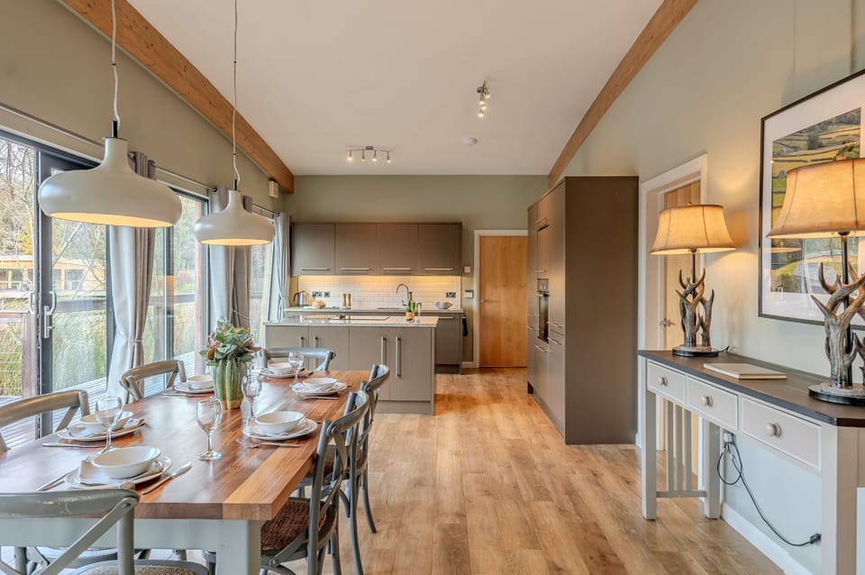 Open-plan kitchen and dining area in Rebecca lodge at Brompton Lakes with lake views and private decking.