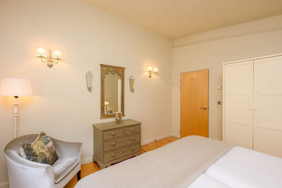 Bedroom in Rebecca lodge at Brompton Lakes with soft furnishings and bedside lamps.
