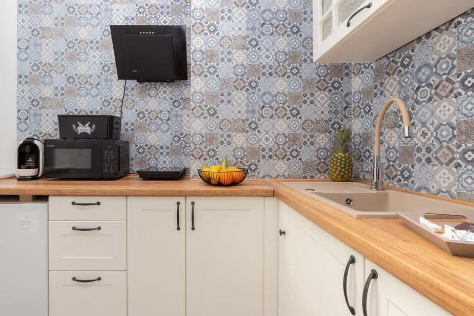 Kitchen area with patterned tile backsplash, fruit bowl, and modern finishes.