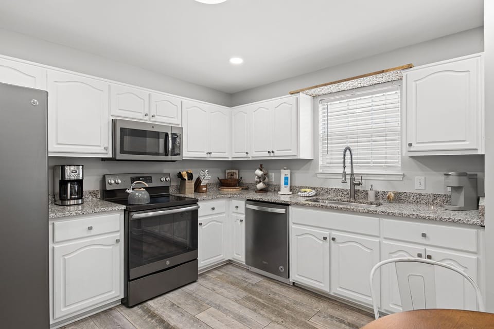 Picture yourself preparing meals in this bright, fully equipped kitchen with modern appliances, granite countertops, and plenty of cabinet space for your culinary adventures.