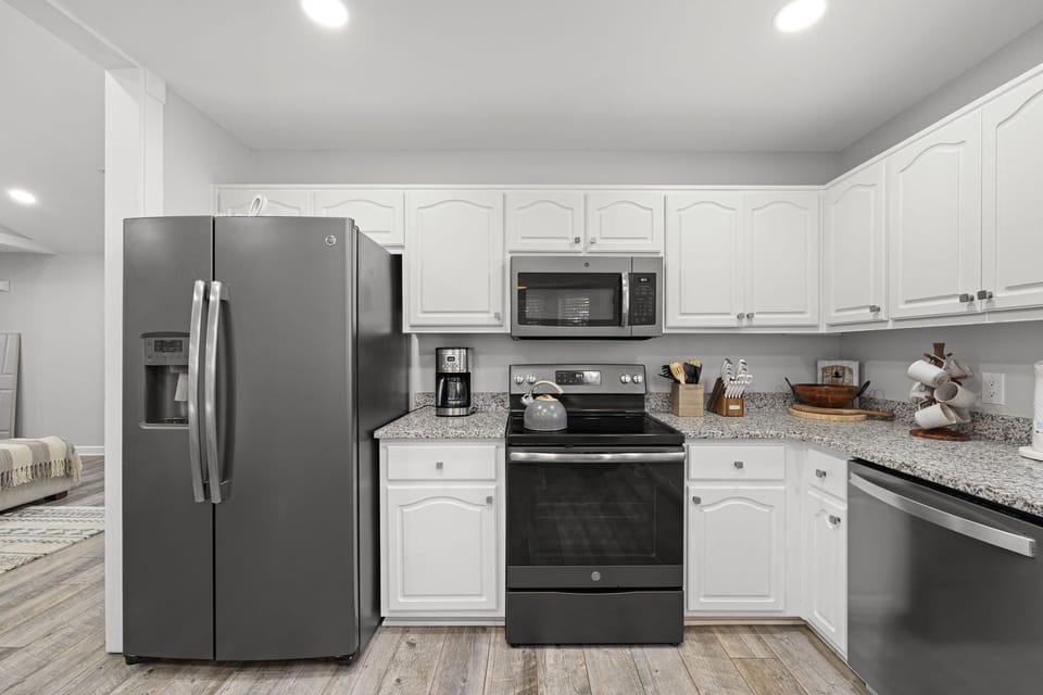 Your fully equipped kitchen features sleek stainless appliances, bright white cabinetry, and spacious granite countertops—perfect for crafting home-cooked meals during your stay.