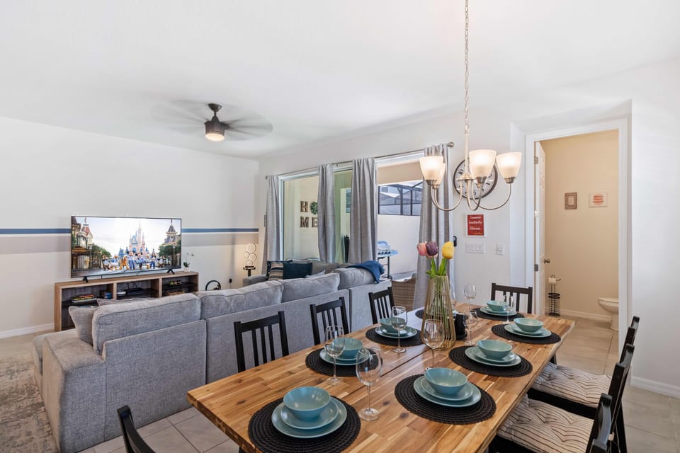 Gather around the table in our welcoming dining area of the home in Kissimmee - Experience our 8 persons dining area enhanced by soft lighting, charming décor, and a cozy ambiance. - Offering a spacious and warm environment for quality time.