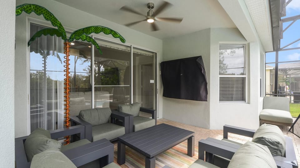 Covered lanai with fan and 65 inch smart TV. Pool door includes safety pool alarm.