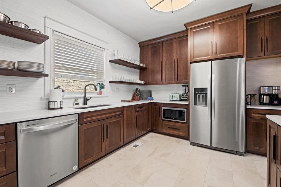 Spacious and beautifully designed kitchen with open shelving, full cookware set, and ample counter space for groups and long-term stays.