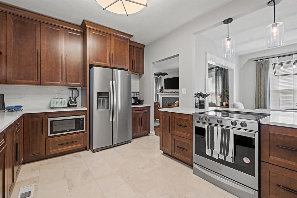 Enjoy a fully stocked, modern kitchen featuring stainless steel appliances, rich wood cabinetry, and everything you need for home-cooked meals during your Hyde Park stay.