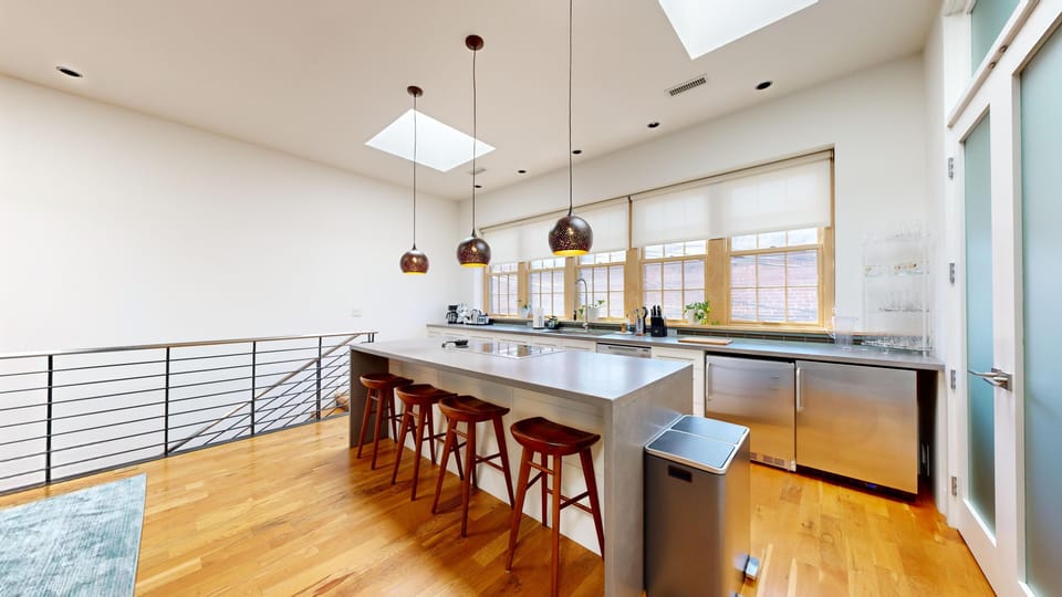 Fully equipped for foodies—this kitchen blends polished finishes with raw industrial flair.