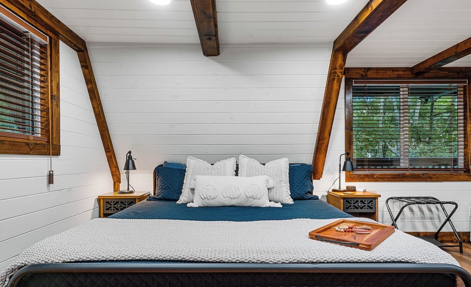 Queen bed made up in navy with nightstands on both sides