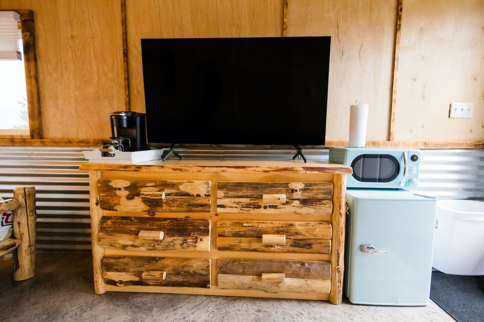 Cabin comforts with TV, coffee bar, and mini fridge for adventures