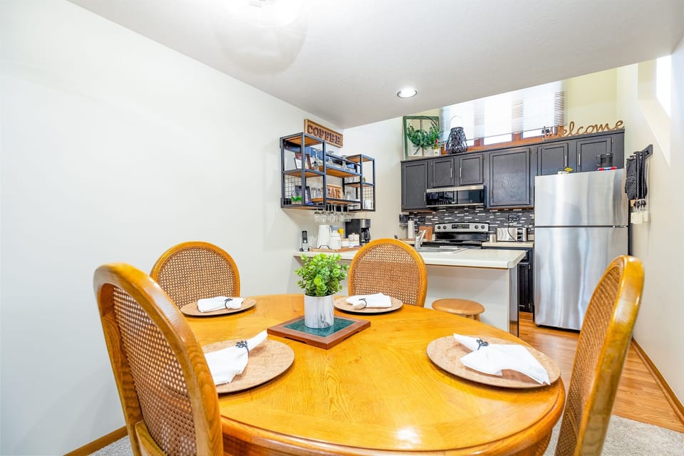 Dining area with seating for four (4), two additional seats at the breakfast bar
