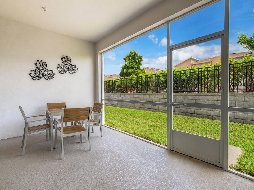 Screened patio with outdoor dining table overlooking the lawn