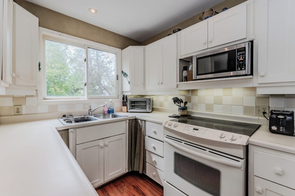 Large windows bring in natural light while you cook, creating a cheerful and welcoming cottage atmosphere.