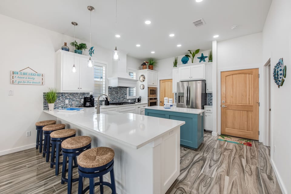 Your spacious kitchen invites culinary adventures with gleaming countertops, modern appliances, and cheerful coastal touches that make cooking feel like a vacation.