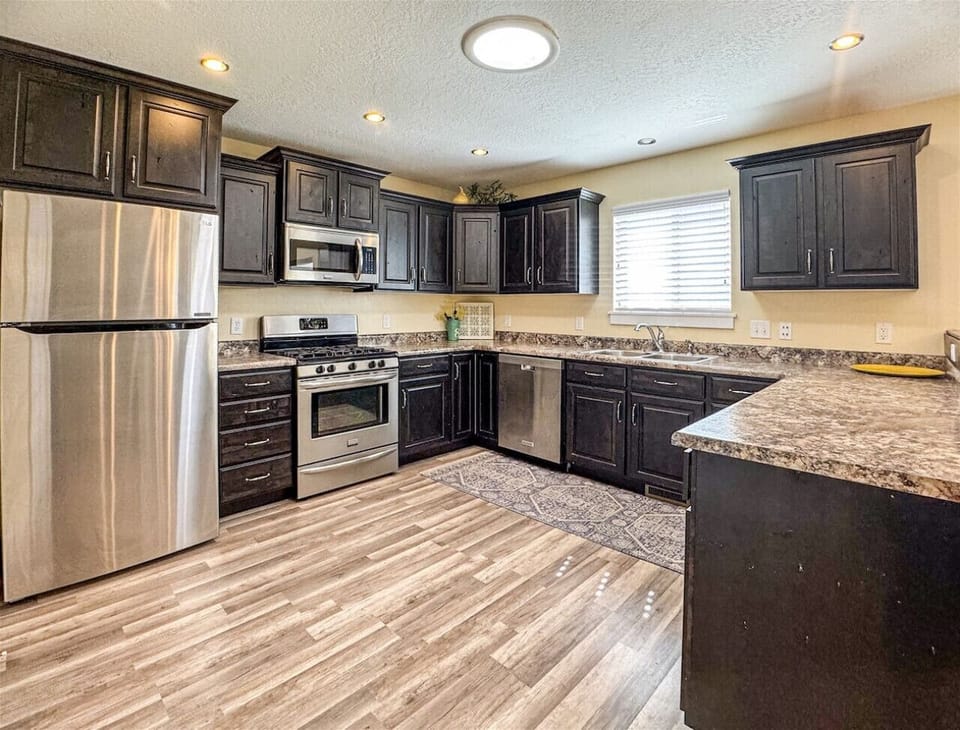 Spacious kitchen with sleek appliances, rich cabinetry, and ample counter space—perfect for cooking and gathering.